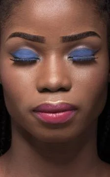 Close up portrait of dark skinned model with closed eyes on black backstage. Stock Photos