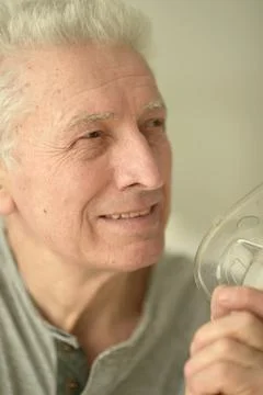 Close-up portrait of an elder man making inhalation Stock Photos