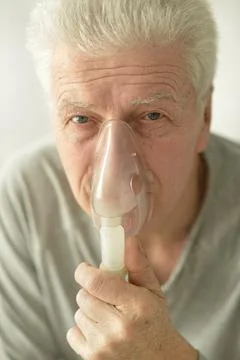 Close-up portrait of an elder man making inhalation Stock Photos