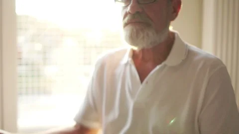 Close portrait of an elderly gray-bearded man sitting on the floor in a lotus Stock Footage 123080329