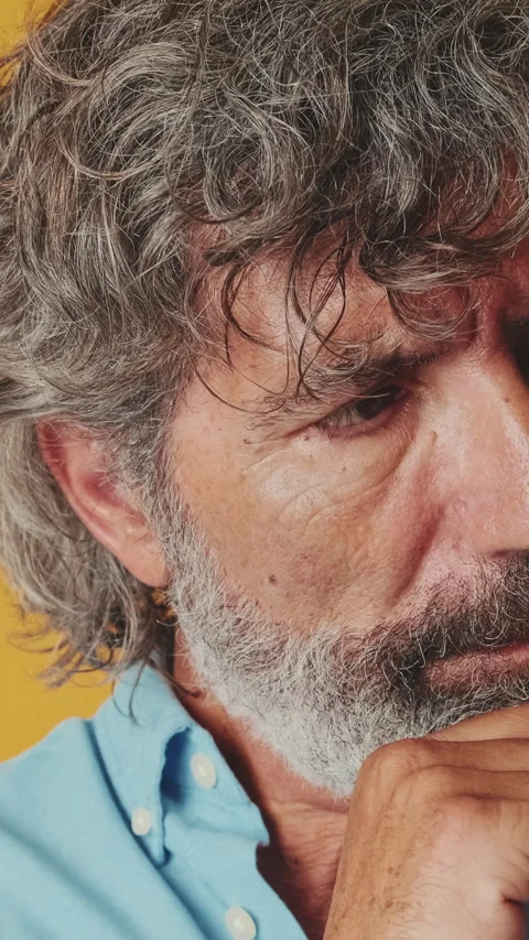 Close up portrait, elderly gray-haired man having doubts,  isolated on orange Stock Footage 255505269