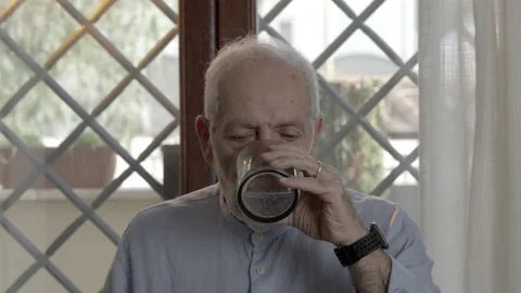 Close-up portrait of an elderly man drinking his fizzy medicine Vídeos de archivo 230883281