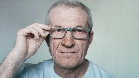 Close-up portrait of an elderly man with glasses looking into the camera Stock Footage 113141949