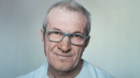 Close-up portrait of an elderly man with glasses looking into the camera. Stock Footage 113142082