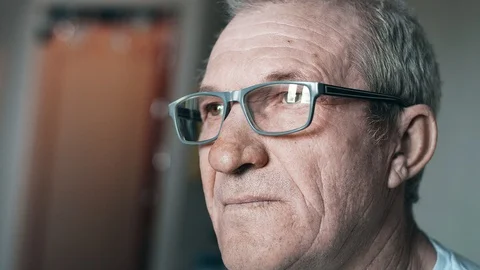 Close-up portrait of an elderly man with glasses, looking away Video stock 113142870