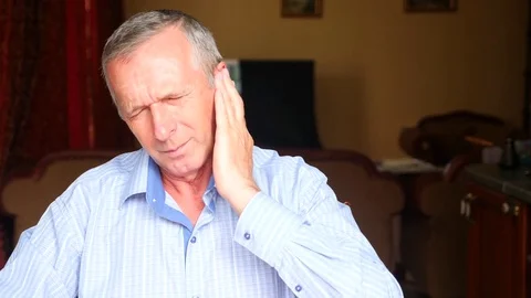 Close-up portrait of an elderly man, his ear hurts. 4k, slow motion Video stock 80353498