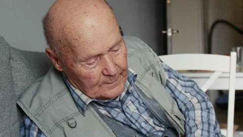 Close up portrait of elderly pensive tired man sitting on sofa at home. Stock Footage 146403852