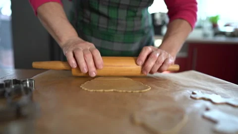 A close portrait of an elderly womans hand rolling out the cookie dough with a Stock Footage 145152003