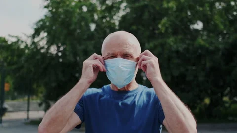 Close up Portrait of Eldery Man while He Put on a Medicine Face Mask and Looking Stock Footage 148468913