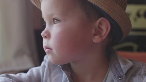 Close-up portrait face child boy bites pink macaroon dessert chews sweets closed Stock Footage 242604039