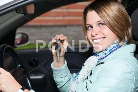 Close up portrait of female driver with car key in hand Stock Photos