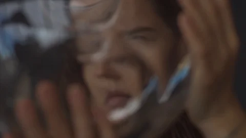 Close up portrait of female face through wavering glass macro detail 4k.  Vidéo 104716552