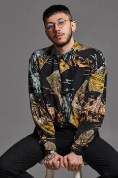 Close-up portrait of a funny guy posing sitting on a bar chair in studio 스톡 사진