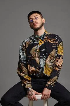 Close-up portrait of a funny guy posing sitting on a bar chair in studio i... 스톡 사진