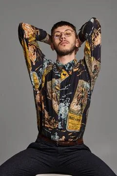 Close-up portrait of a funny guy posing sitting on a bar chair in studio i... 스톡 사진