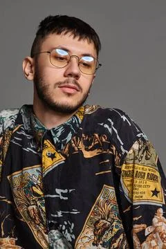 Close-up portrait of a funny guy posing in studio isolated on a gray backg... 스톡 사진