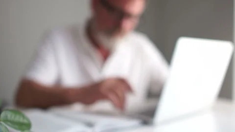 Close portrait of a gray-haired mature man with a beard and glasses working with Stock Footage 120796841