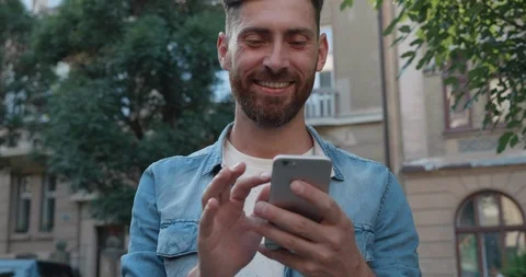 Close up Portrait of Handsome Bearded Man Standing in the Yard with Mobile Phone Stock Footage 122993034