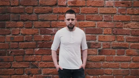Close up portrait of handsome bearded man near brick wall. Looking at camera Stock Footage 133917876