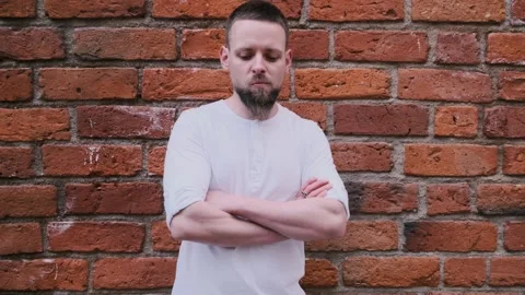 Close up portrait of handsome bearded smiling young man near brick wall Stock Footage 132312202