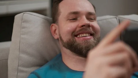 Close-up portrait of a handsome man typing and texting on his smartphone at home Stock Footage 108788142