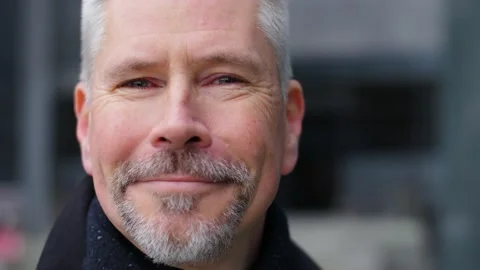 Close-up portrait of handsome middle aged man turning his head and smiling. Video stock 165210513