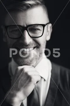 A close up portrait of a handsome smiling mature man posing in the studio ove Stock Photos