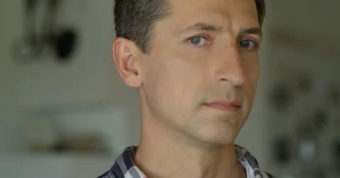Close-up portrait of a handsome young man with blue eyes looking at camera and Stock Footage 66074348