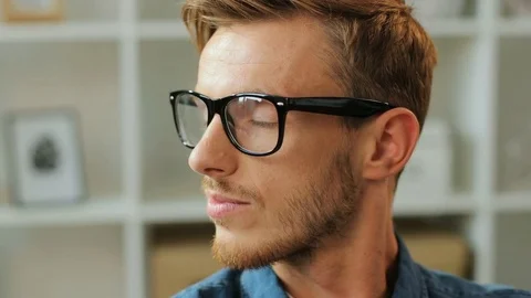 Close up portrait of handsome young man in the glasses turning at the camera and Stock Footage 79999759
