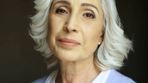 Close up portrait of happy old woman turning and smiling at camera. Indoor shot. Stock Footage