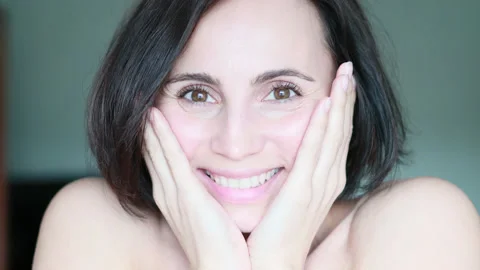Close-up portrait of happy woman touching her face and smiling Stock Footage