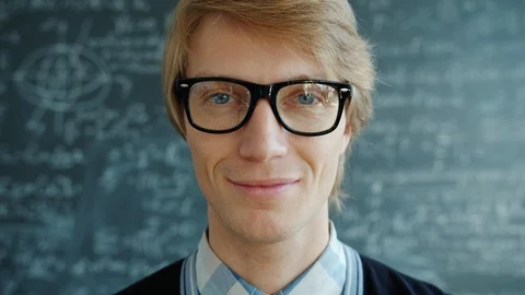 Close-up portrait of happy young man smiling wearing glasses in university Stock Footage 125020337