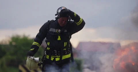 Close-up portrait of a heroic fireman in a protective suit. Firefighter in fire Stock Footage 248009014