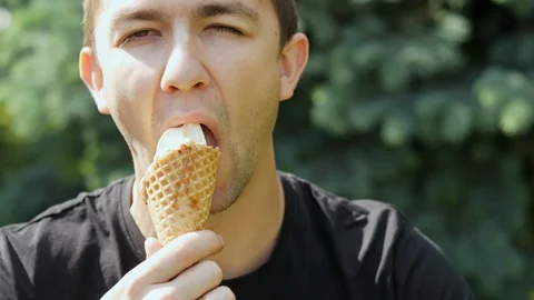 Close-up portrait of hungry young man eating ice cream Stock Footage 108515230