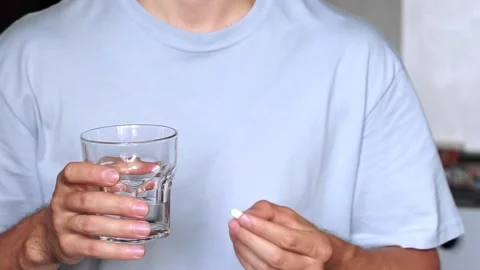 Close up portrait of ill man putting white pill in mouth. Sick male taking me Stock Footage 164171100