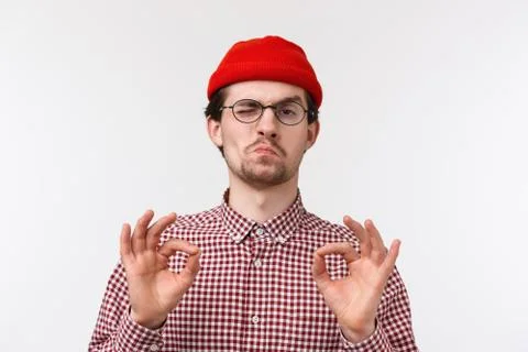 Close-up portrait impressed good-looking young hipster guy in red beanie Stock Photos