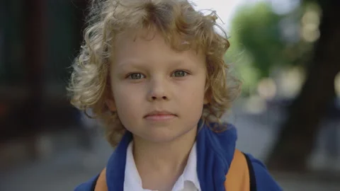 Close up portrait of joyful schoolboy standing on school yard with bag turn Stock Footage 201409696