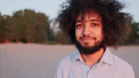 Close-up Portrait of Joyful Young Hispanic Man Curly Hair, Standing Alone in Stock Footage 148551244