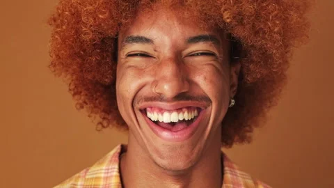 Close up, portrait of a laughing guy looking at the camera isolated on brown Stock Footage 253932661