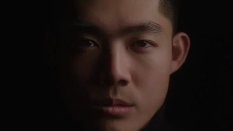 Close-up  Portrait of Light Passing over Serious Male Model Face in Dark Studio Видео 270305457