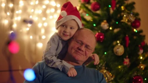 Close up portrait of little boy hugging his smiling grandpa on Christmas Eve Stock Footage 73044663