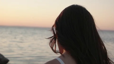 Close up portrait looking at sunset over ocean. Woman with hair blowing in wind Stock Footage 88718926