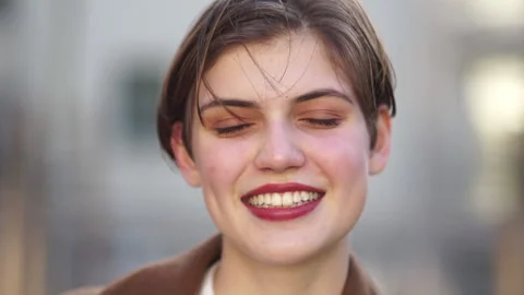 Close portrait of a lovely short-haired young woman. The girl smiles and Stock Footage 163842015