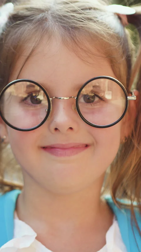 Close up. Portrait of lovely small school girl in glasses with backpack smiling  Stock Footage 331798384
