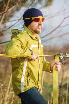 Close-up portrait of a man adjusting slacklining equipment before performing Stock Photos