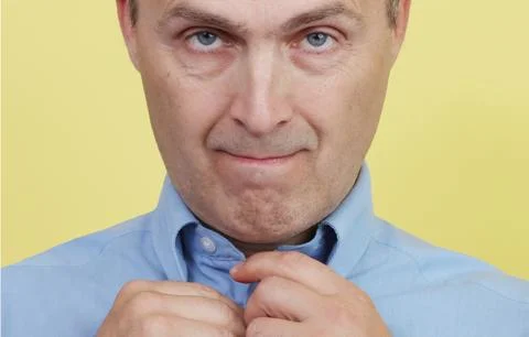 Close-up portrait of a man buttoning his shirt. Stock Photos