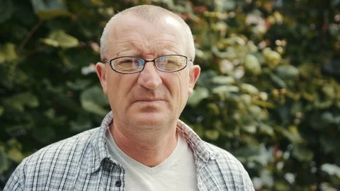 Close up portrait man with glasses standing in garden looking at the camera Stock Footage 102779625