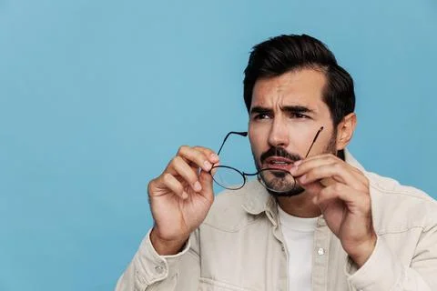 Close-up portrait of a man looking through glasses that he holds in his hands Stock Photos