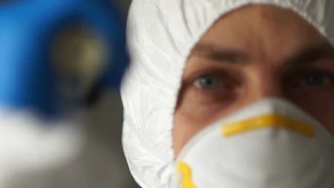 Close up portrait of a man in a protective suit, mask, gloves and glasses shines Stock Footage 126499701