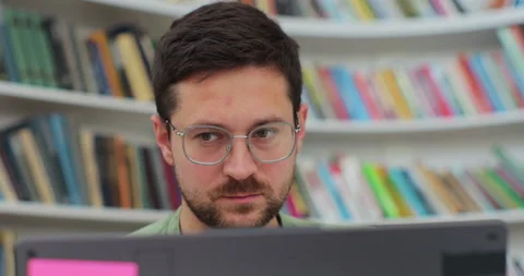 Close up portrait man student preparing exam and learning lessons in library Stock Footage 208818464